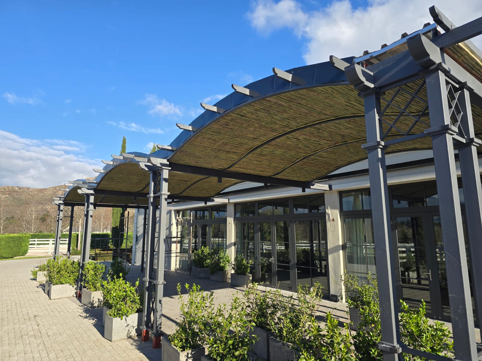Custom architectural steel pergola with bamboo reed shading